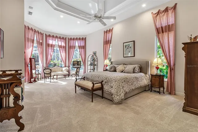 a spacious bedroom with a bed mirror and a desk