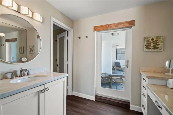 a en suite bathroom with a granite countertop sink and a mirror