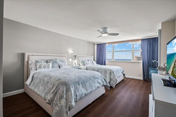 a bedroom with a large bed and a flat tv screen on dresser