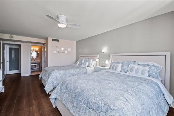 a bedroom with a large bed and wooden floor