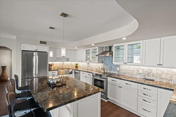 a kitchen with stainless steel appliances granite countertop a sink stove and refrigerator