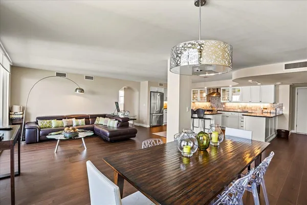 a living room with dining table or chandelier couches and kitchen view