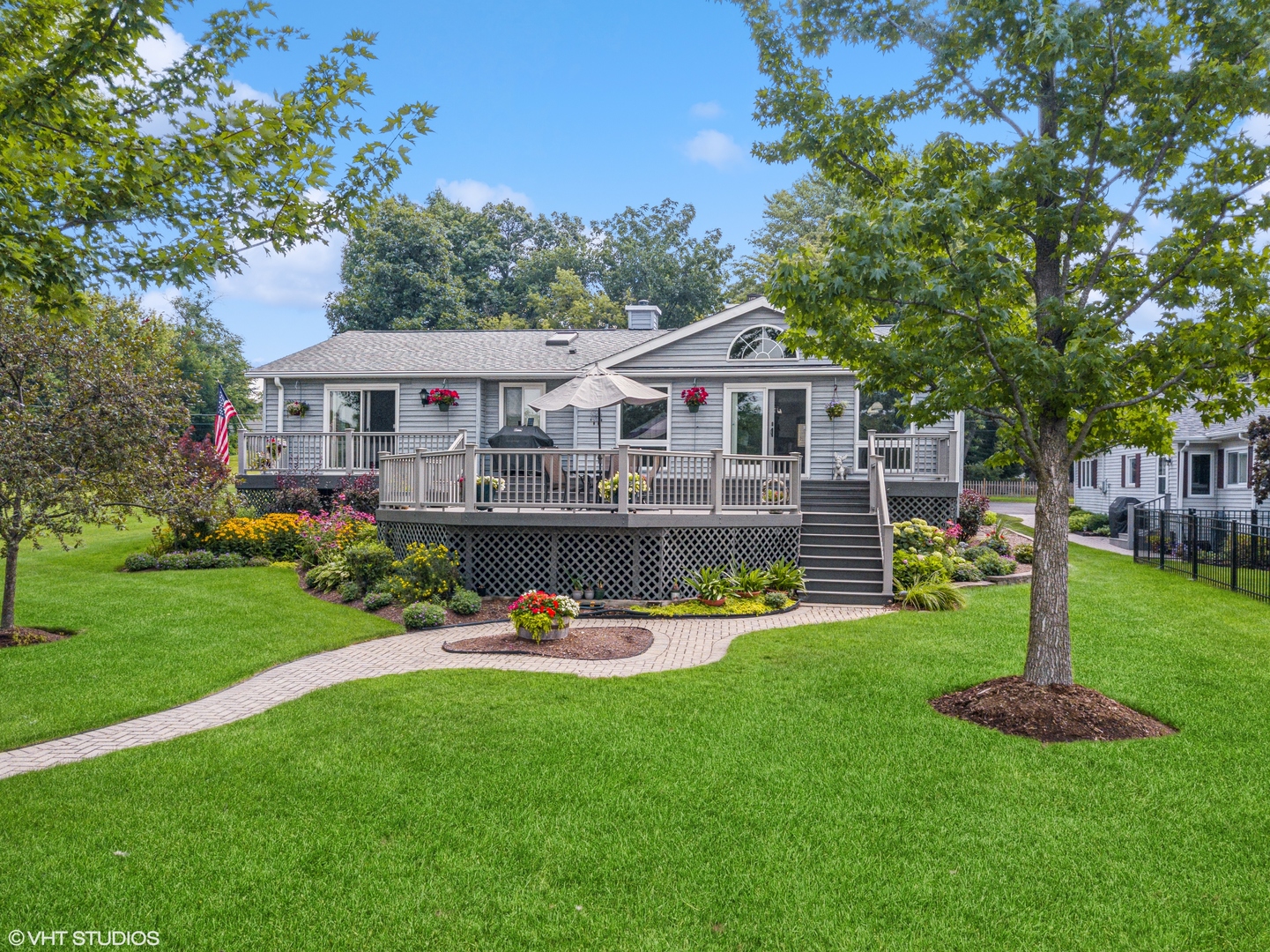 a front view of a house with garden and trees
