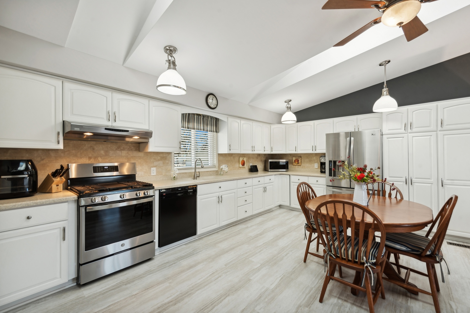 307 North Emerald Drive McHenry, IL 60051 - Photo 14 of 34 a kitchen with stainless steel appliances a stove a sink dishwasher a dining table and chairs with wooden floor