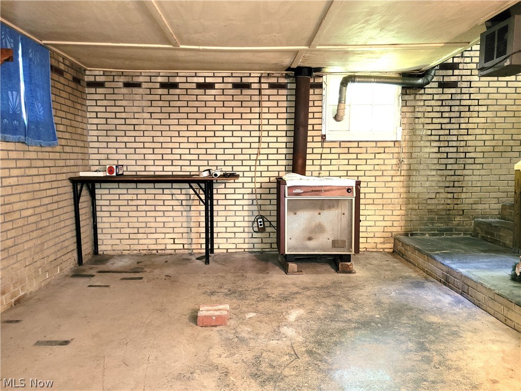 50658 Marietta Road Cumberland, OH 43732 - Photo 14 of 14 Basement with brick wall and a wood stove