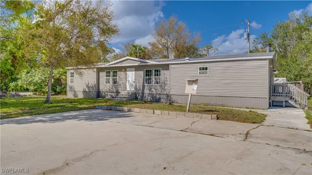 a view of a house with a backyard and a tree
