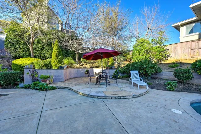 a view of a patio with a table and chairs under an umbrella