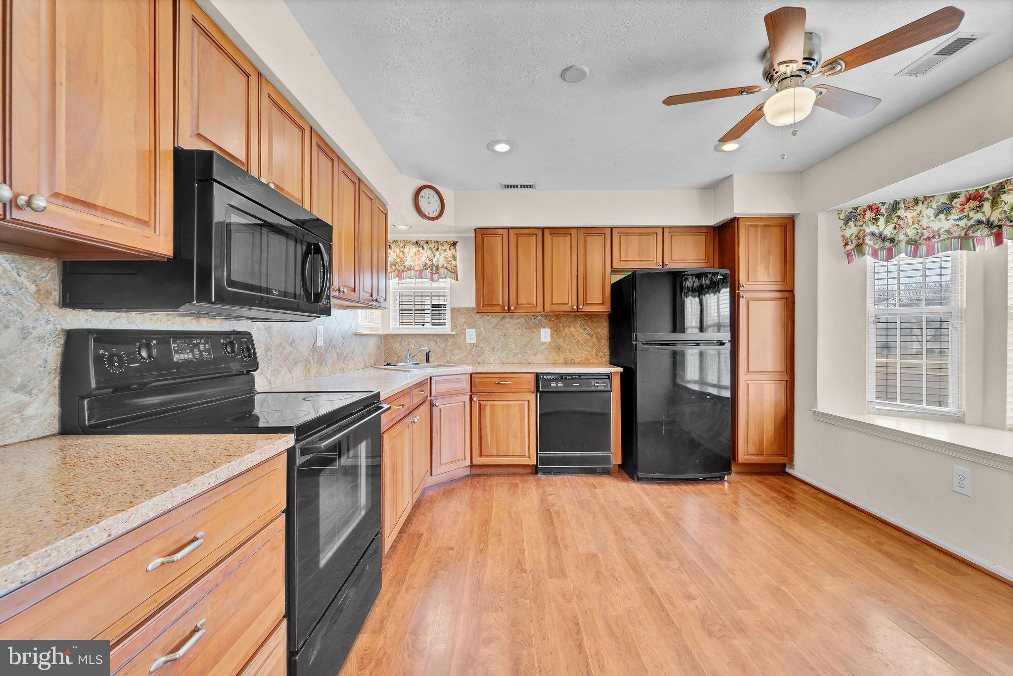 310 Moonseed Place Mount Laurel, NJ 08054 - Photo 5 of 27 a kitchen with stainless steel appliances granite countertop a refrigerator a stove top oven a sink dishwasher and wooden cabinets with wooden floor