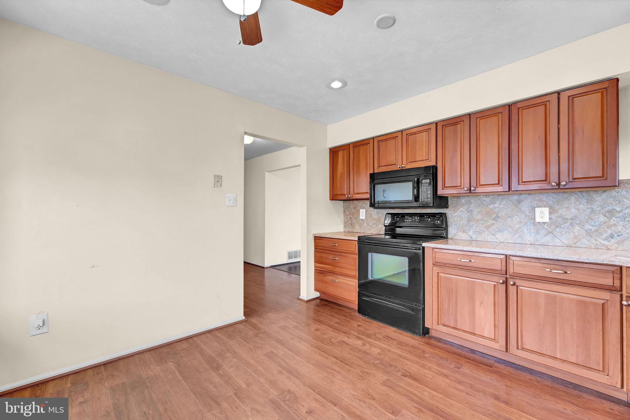 310 Moonseed Place Mount Laurel, NJ 08054 - Photo 7 of 27 a kitchen with granite countertop a stove top oven a sink dishwasher and a microwave oven with wooden floor