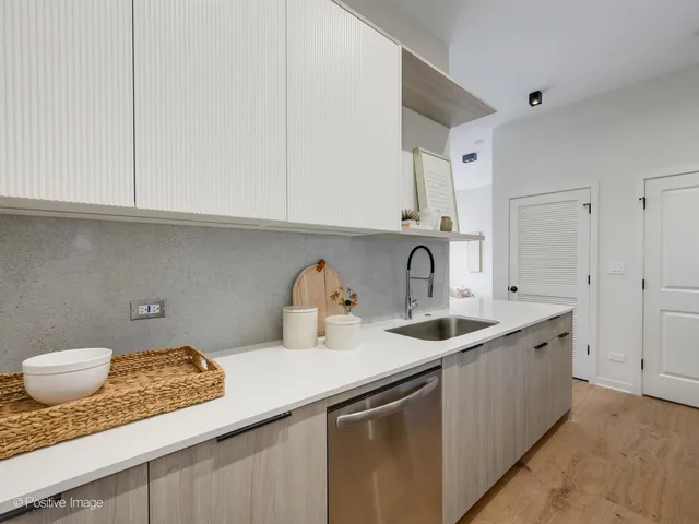 a kitchen with kitchen island granite countertop a sink and white cabinets