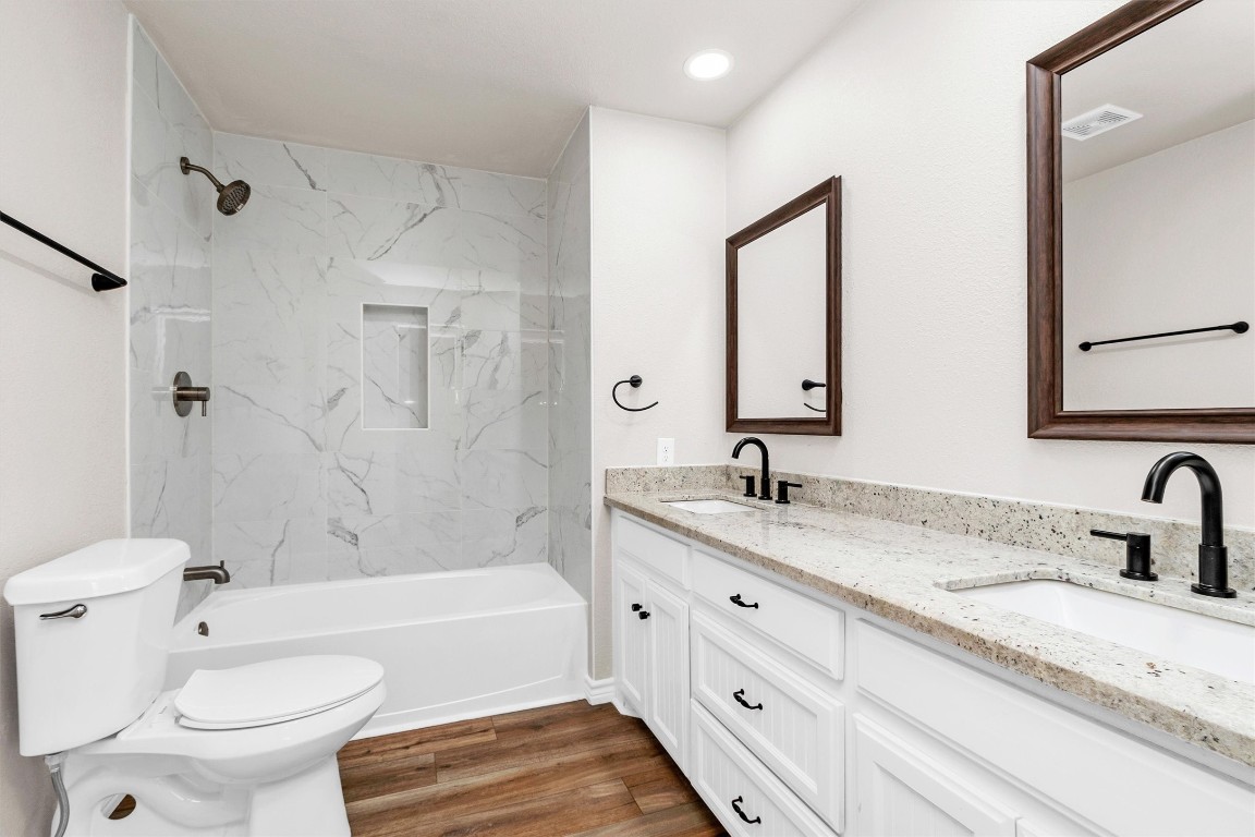 338 South Walker Road Conroe, TX 77306 - Photo 11 of 25 a bathroom with a granite countertop sink toilet mirror and bathtub