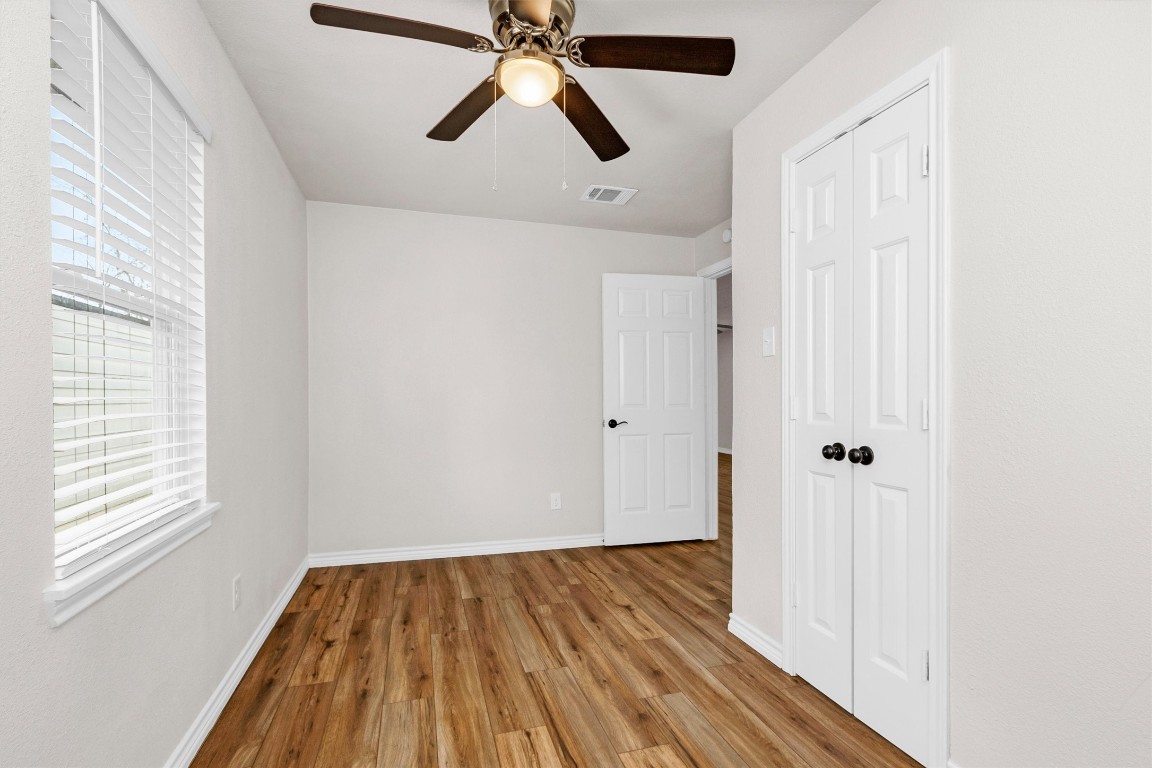 338 South Walker Road Conroe, TX 77306 - Photo 13 of 25 a view of a hallway with wooden floor and a chandelier fan
