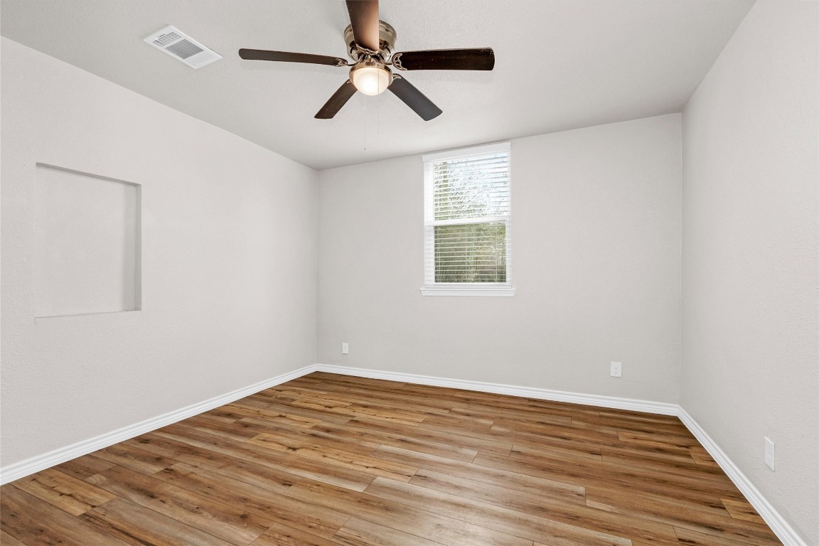 338 South Walker Road Conroe, TX 77306 - Photo 15 of 25 an empty room with wooden floor fan and windows