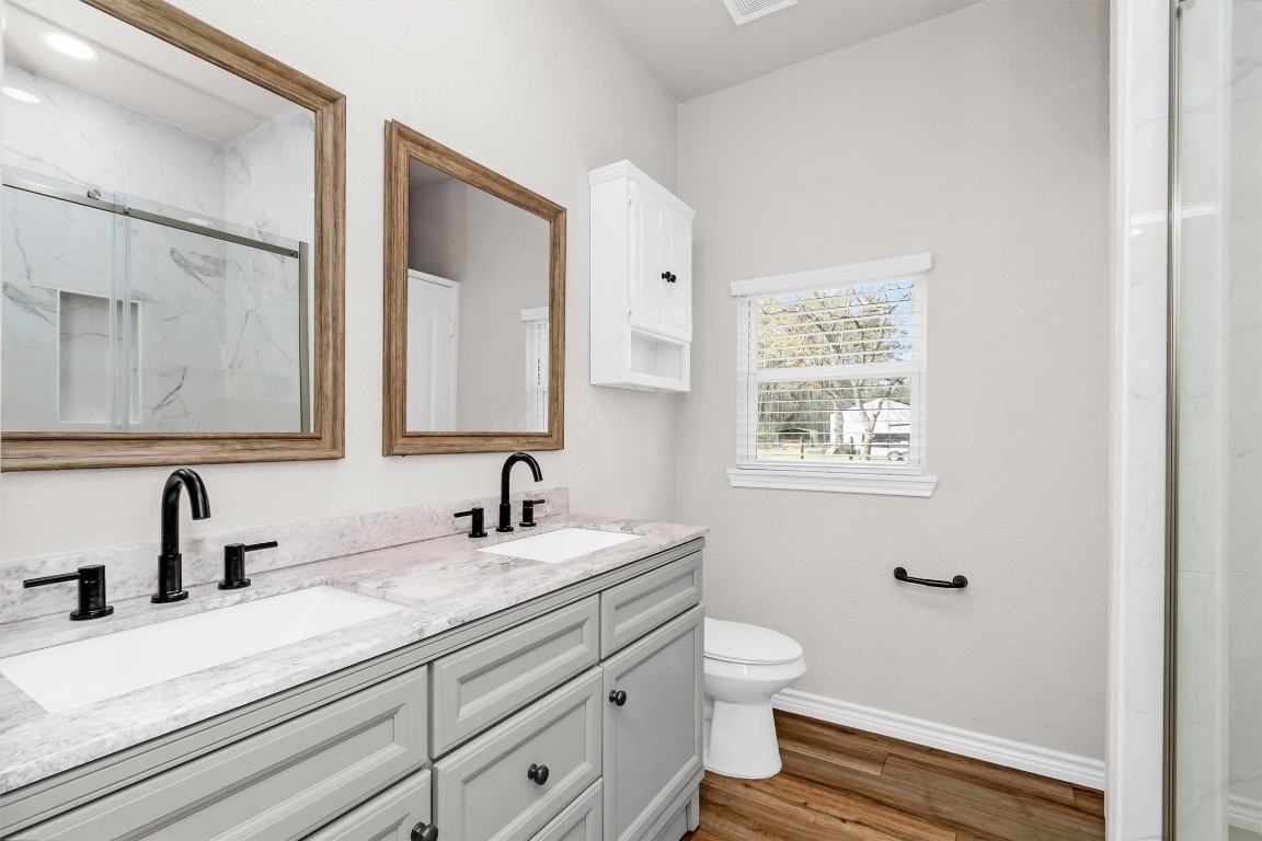 338 South Walker Road Conroe, TX 77306 - Photo 19 of 25 a bathroom with a double vanity sink mirror and toilet