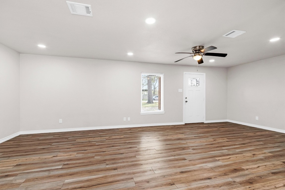 338 South Walker Road Conroe, TX 77306 - Photo 4 of 25 a view of an empty room with wooden floor and a ceiling fan