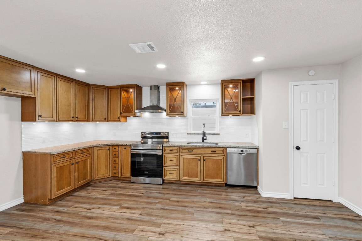 338 South Walker Road Conroe, TX 77306 - Photo 7 of 25 a kitchen with stainless steel appliances granite countertop a stove top oven sink and cabinets