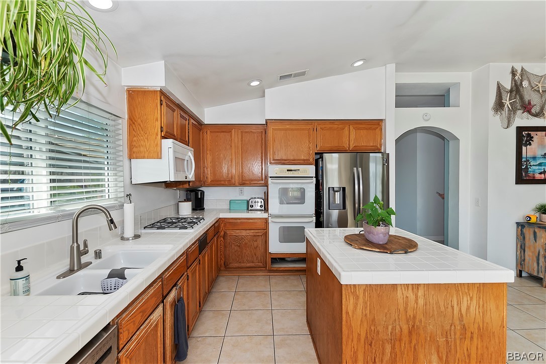 2201 Wagon Train Street Corona, CA 92878 - Photo 7 of 24 a kitchen with stainless steel appliances a sink stove refrigerator and cabinets