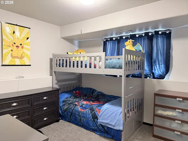 a bedroom with a bed window and a night stand