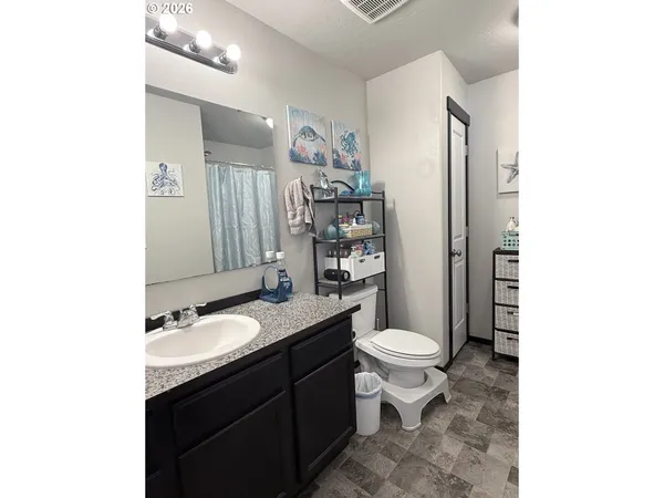 a bathroom with a granite countertop toilet sink and mirror