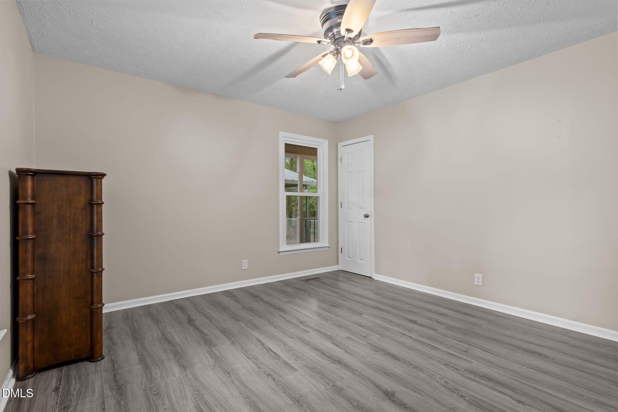 804 West Scotsdale Road Laurinburg, NC 28352 - Photo 20 of 41 an empty room with wooden floor chandelier fan and windows