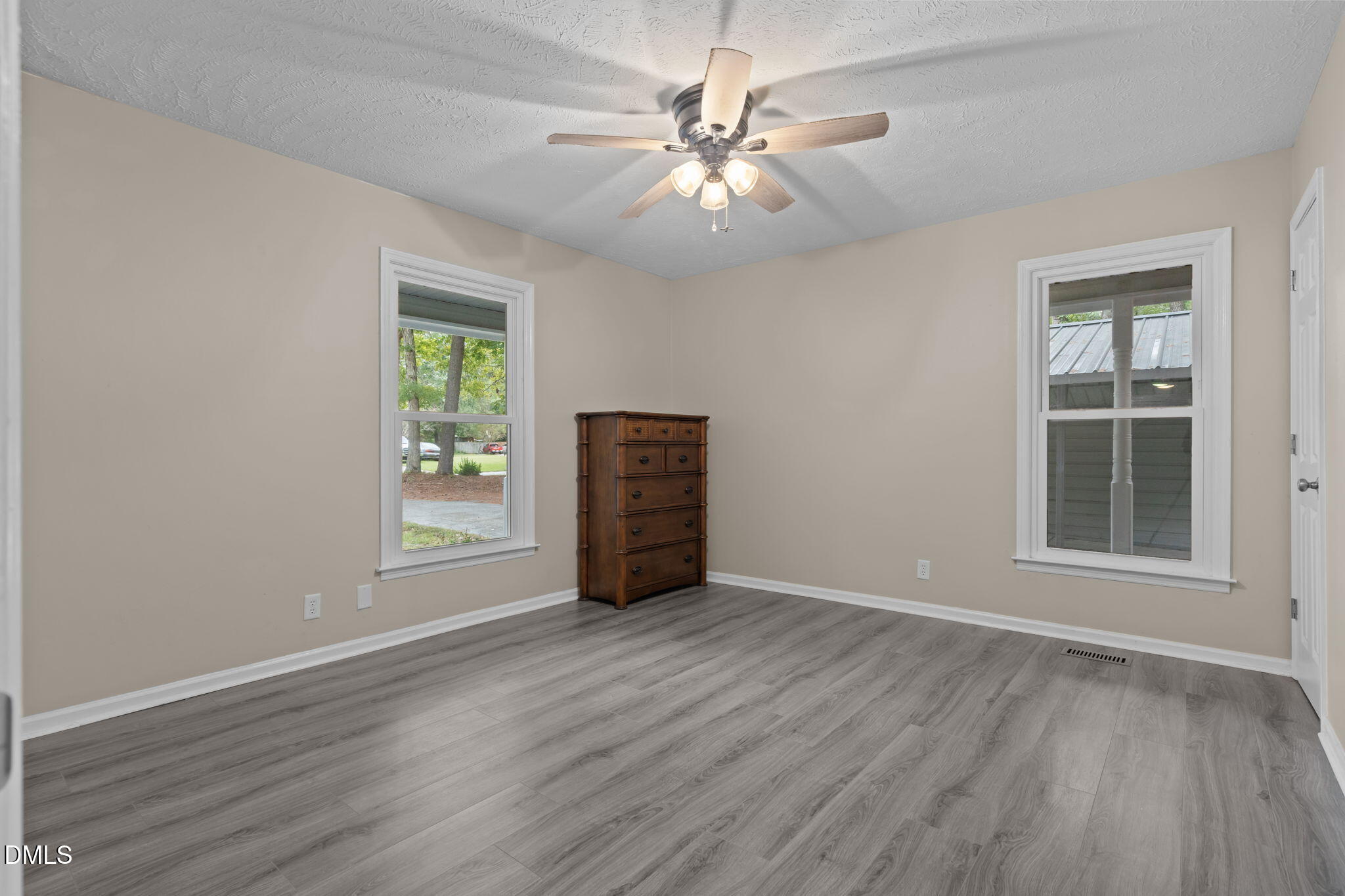 804 West Scotsdale Road Laurinburg, NC 28352 - Photo 22 of 46 an empty room with wooden floor chandelier fan and windows