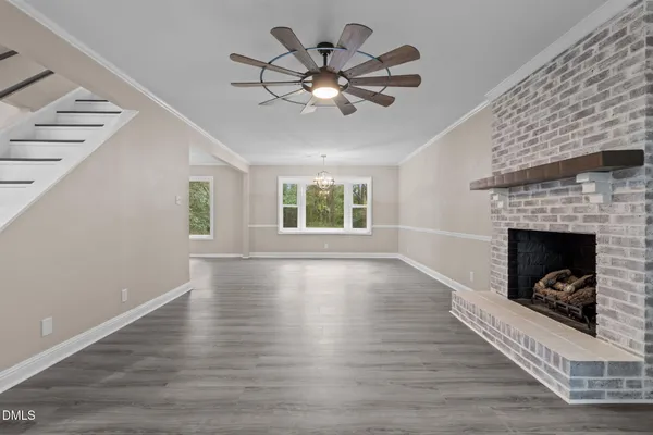 a kitchen with stainless steel appliances granite countertop a sink a stove top oven a refrigerator with white cabinets and wooden floor