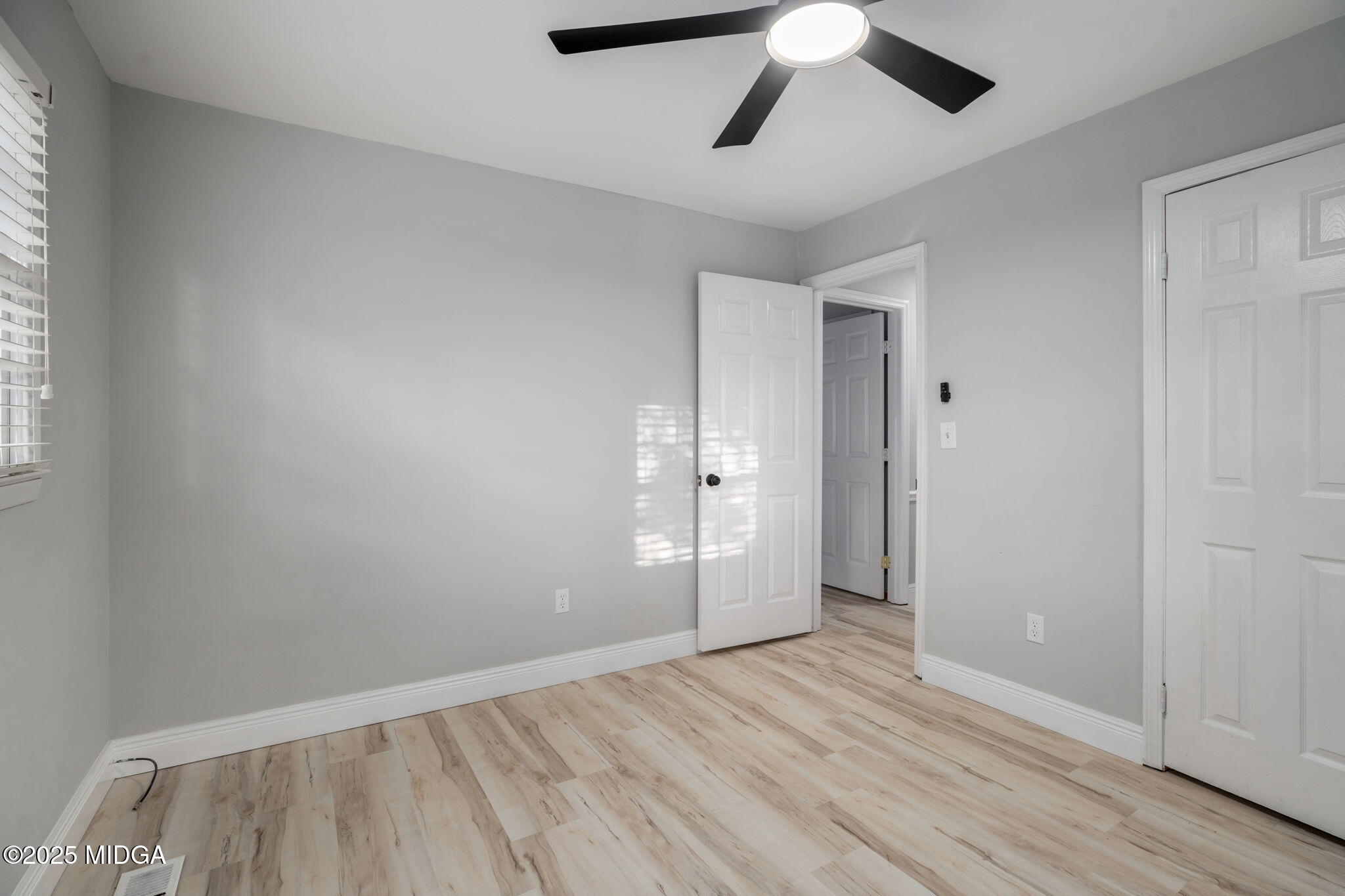 113 Colonial Road Warner Robins, GA 31088 - Photo 26 of 34 an empty room with wooden floor ceiling fan and windows
