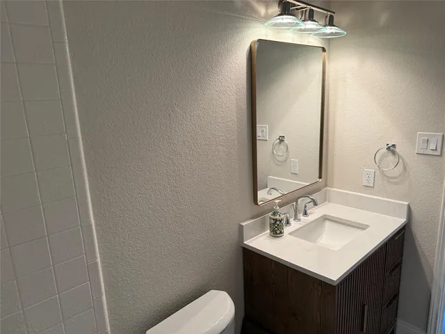 a bathroom with a sink toilet and mirror