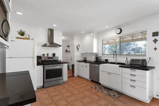 a kitchen with stainless steel appliances kitchen island granite countertop a stove a sink and a refrigerator