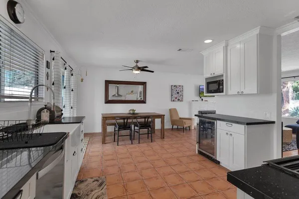 a view of a patio with table and chairs potted plants with floor to ceiling window and potted plants