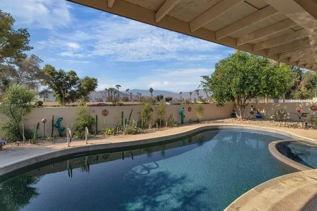 a view of house with swimming pool and sitting area