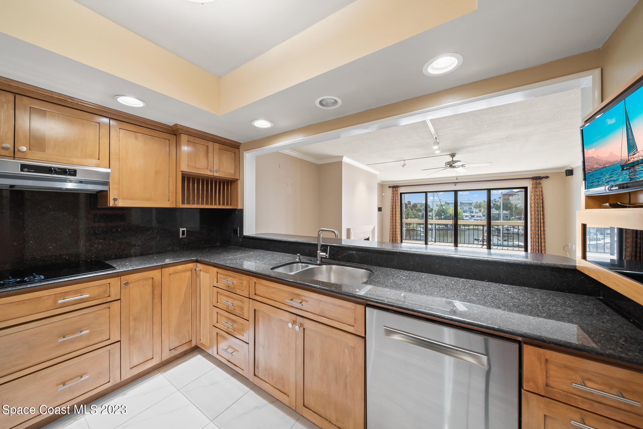 2220 Front Street, Unit 303 Melbourne, FL 32901 - Photo 6 of 24 a kitchen with granite countertop stainless steel appliances a sink and cabinets