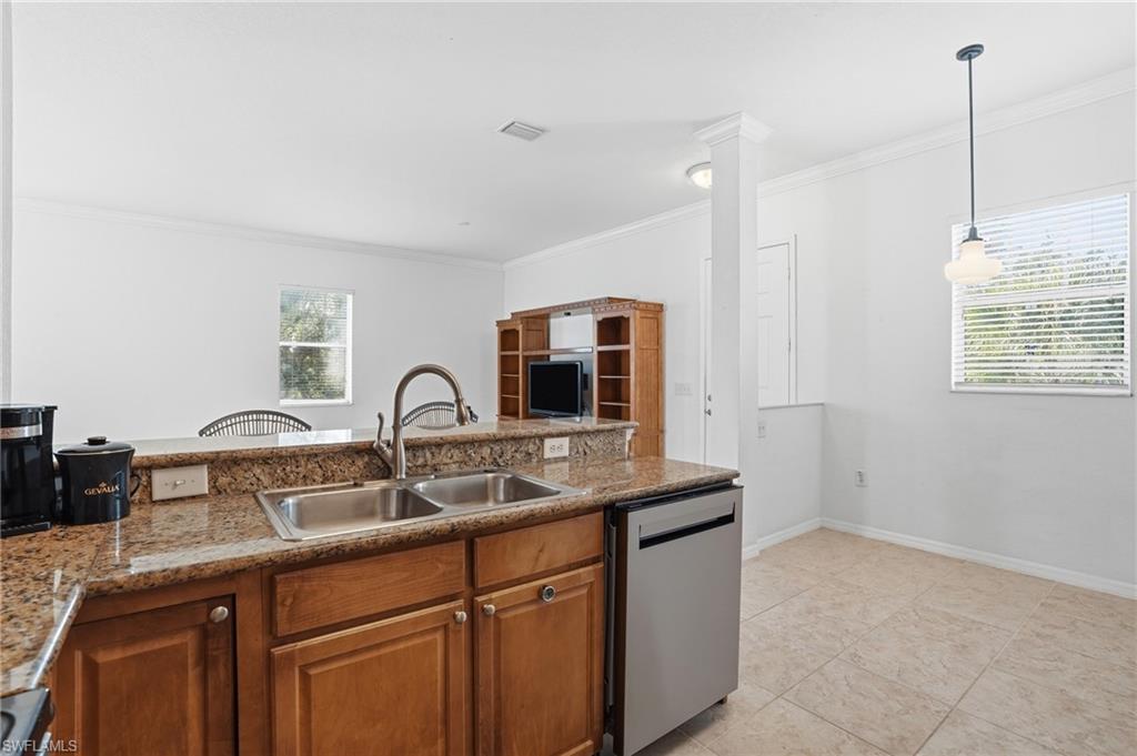 970 Peggy Circle, Unit 604 Naples, FL 34113 - Photo 14 of 24 Kitchen featuring brown cabinetry, dishwasher, crown molding, pendant lighting, and light tile patterned floors
