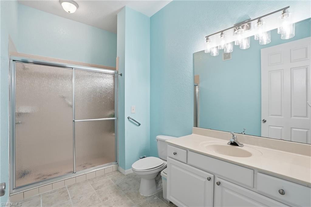 970 Peggy Circle, Unit 604 Naples, FL 34113 - Photo 16 of 24 Bathroom with vanity, a shower stall, and a textured wall