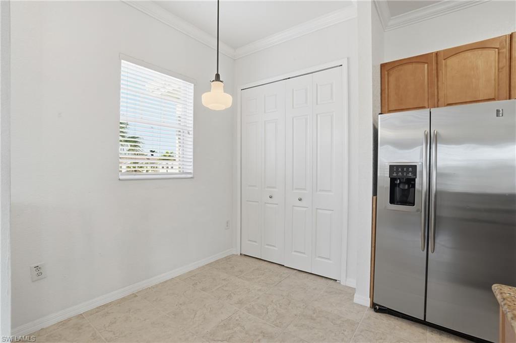 970 Peggy Circle, Unit 604 Naples, FL 34113 - Photo 19 of 24 Kitchen with stainless steel fridge, crown molding, and decorative light fixtures