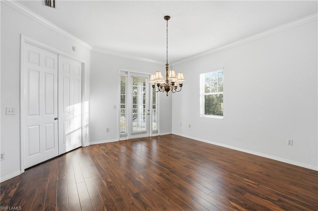 970 Peggy Circle, Unit 604 Naples, FL 34113 - Photo 6 of 24 Unfurnished dining area featuring ornamental molding, dark wood finished floors, and a chandelier