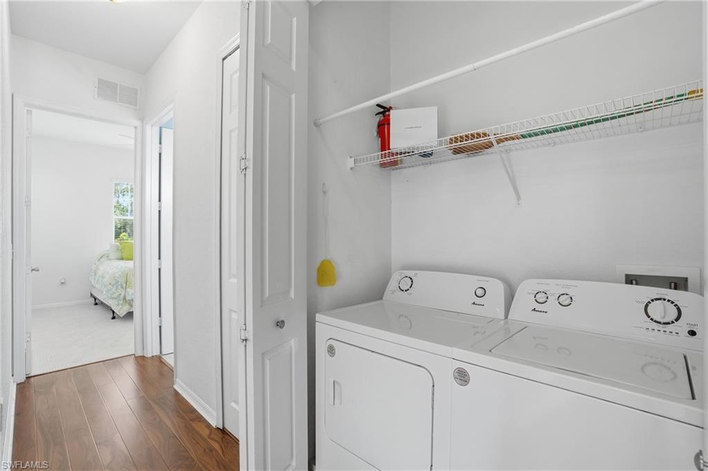 970 Peggy Circle, Unit 604 Naples, FL 34113 - Photo 10 of 24 Laundry room featuring dark wood-type flooring and washing machine and dryer