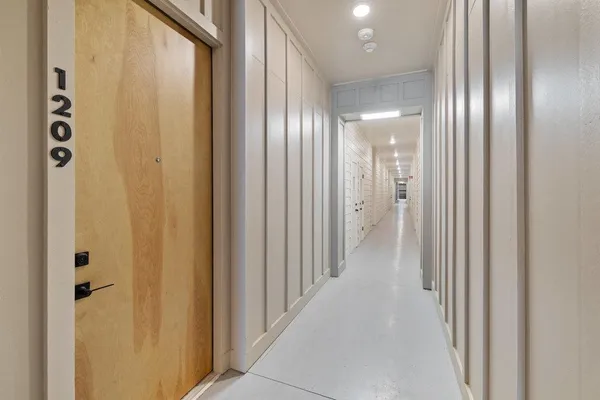 a view of a hallway with stainless steel appliances