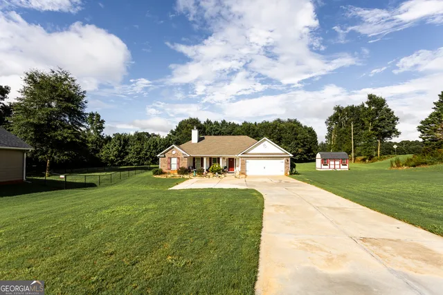 a front view of a house with yard and green space