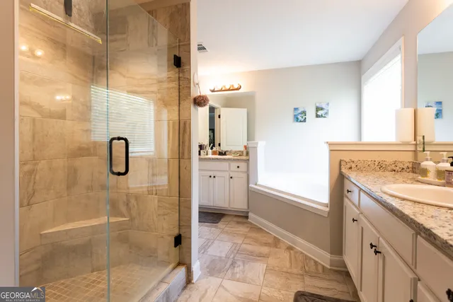 a bathroom with a granite countertop sink a shower and a mirror