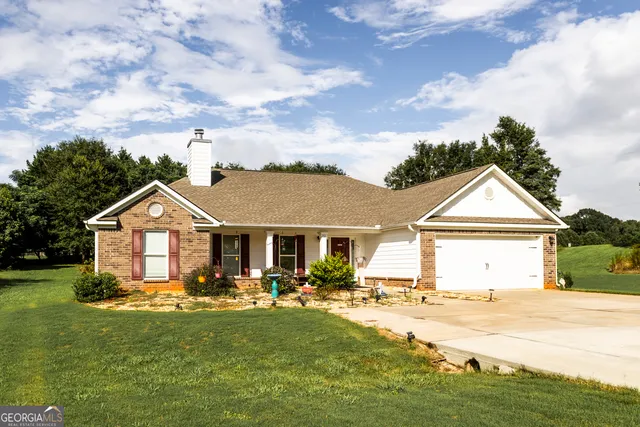 a front view of a house with a garden and lake view