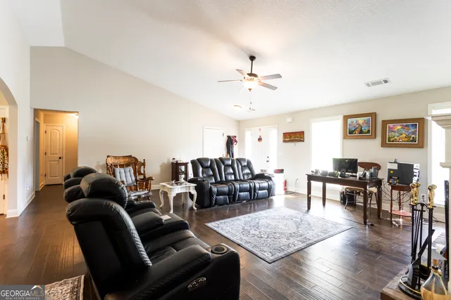a living room with furniture and wooden floor