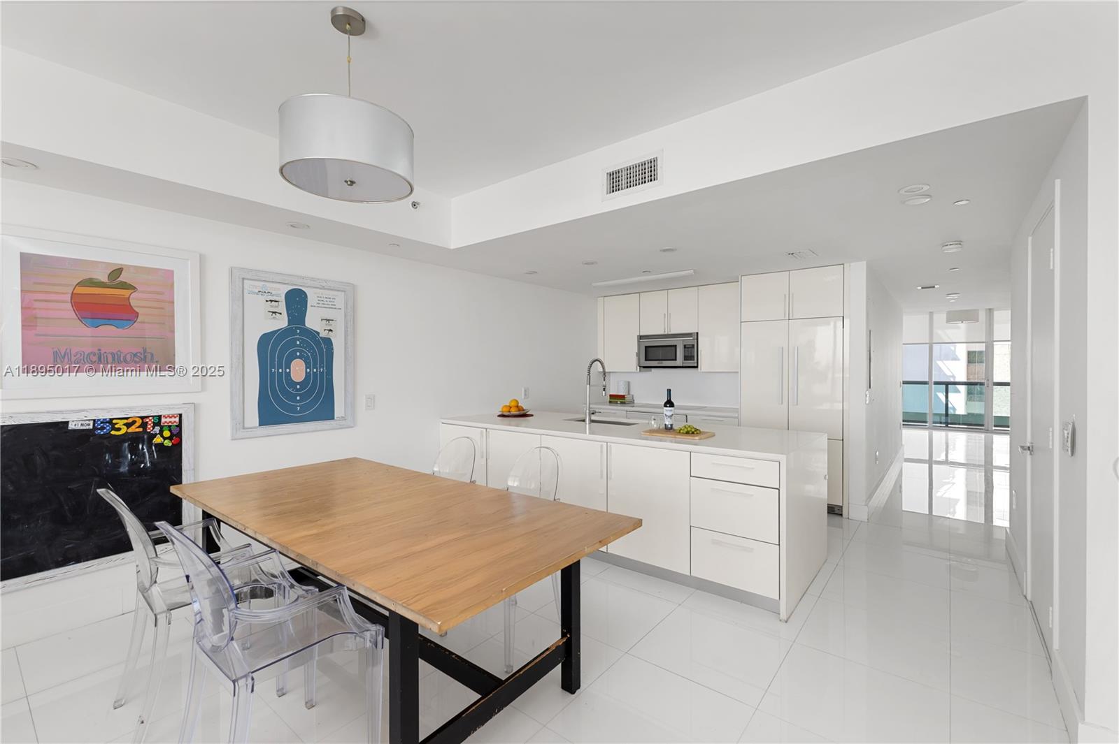 7935 East Drive, Unit 803 Miami Beach, FL 33141 - Photo 12 of 77 a kitchen with stainless steel appliances a table chairs and a refrigerator