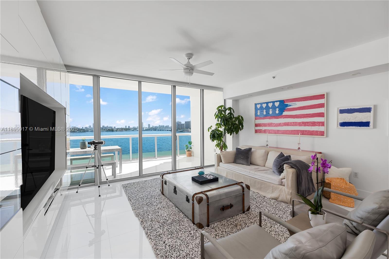 7935 East Drive, Unit 803 Miami Beach, FL 33141 - Photo 59 of 77 a living room with furniture flat screen tv and a floor to ceiling window