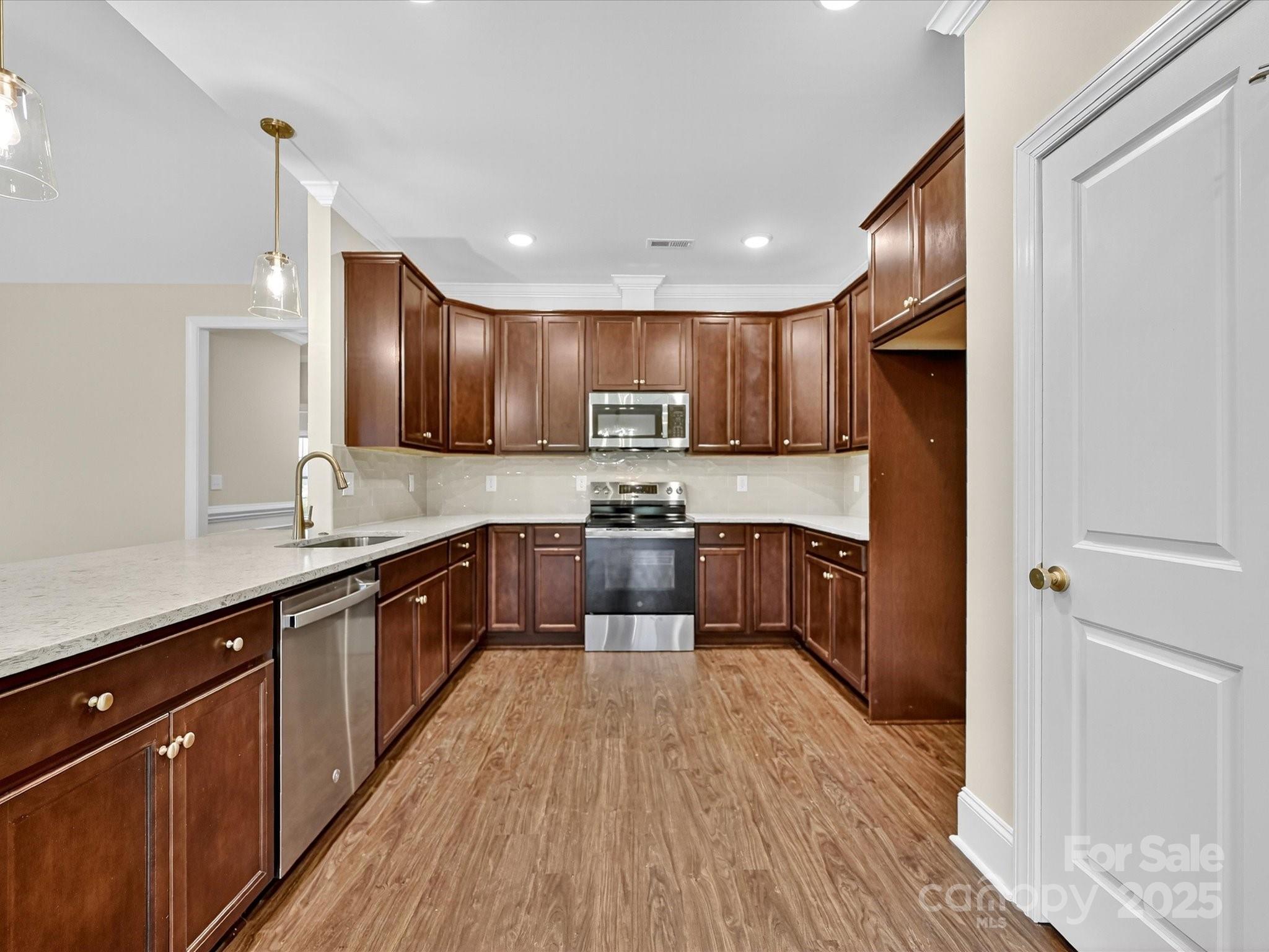 3030 Buffett Lane, Unit 49 Monroe, NC 28110 - Photo 8 of 27 a large kitchen with stainless steel appliances granite countertop a large counter top a sink a stove a refrigerator and cabinets