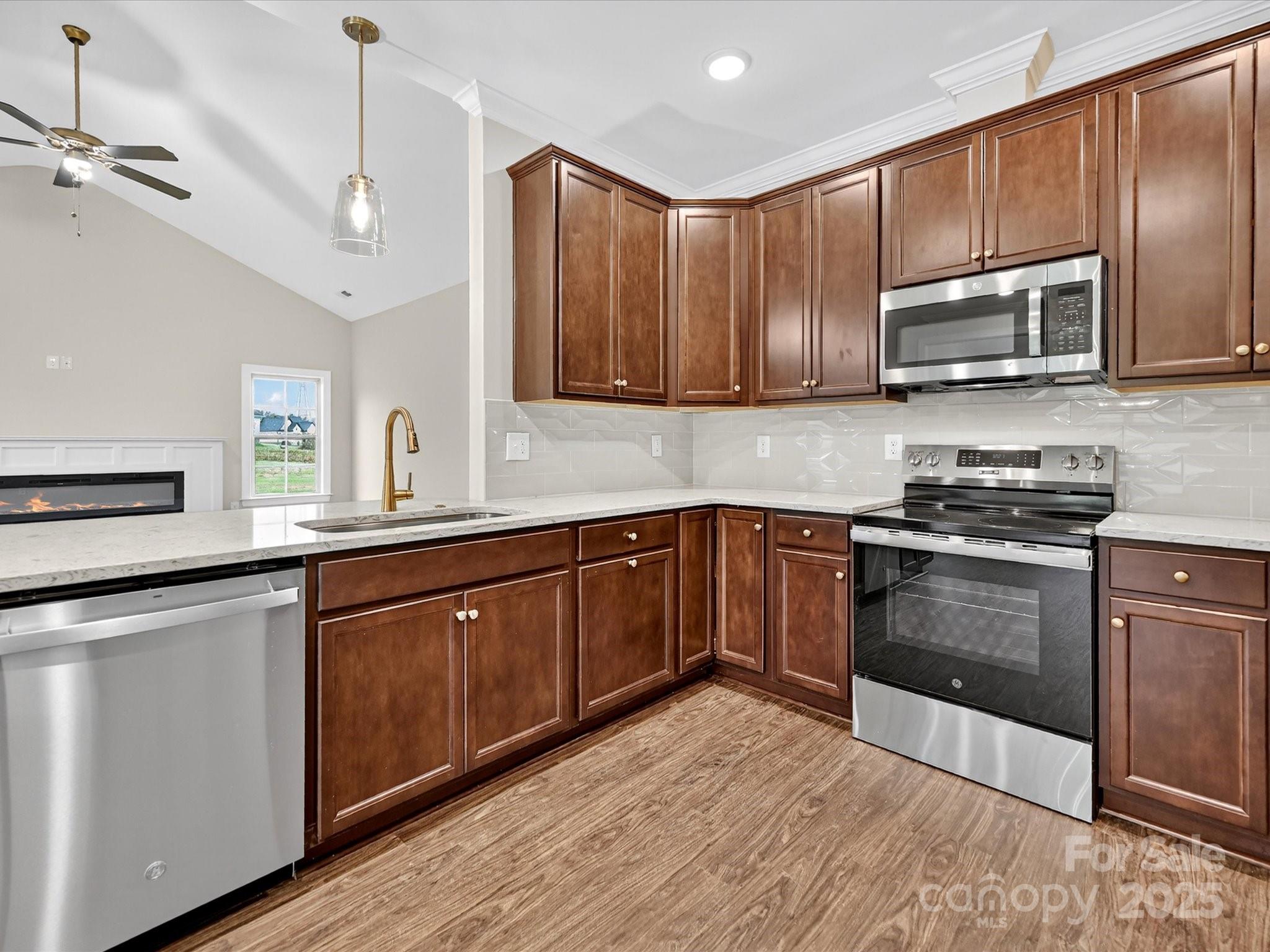 3030 Buffett Lane, Unit 49 Monroe, NC 28110 - Photo 9 of 27 a kitchen with stainless steel appliances granite countertop wooden cabinets a stove top oven a sink and dishwasher