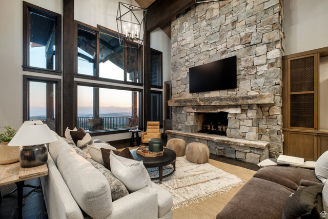 9156 Forest Road, Unit 24 Heber City, UT 84036 - Photo 5 of 42 Floor-to-ceiling windows with dark wood framing, a stone-clad fireplace with a natural wood mantel, built-in wooden cabinetry, and exposed ceiling beams