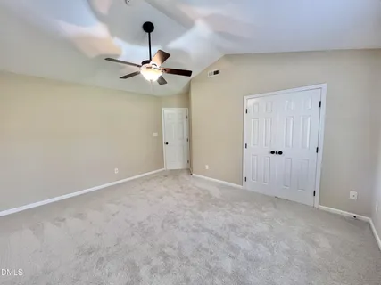 an empty room with windows and cabinet area
