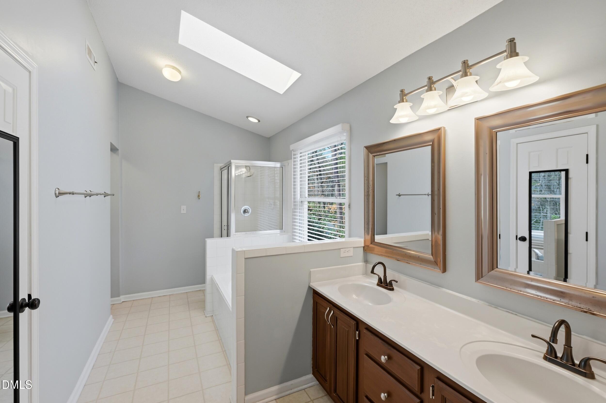 1713 Tealwood Place Raleigh, NC 27615 - Photo 14 of 26 a bathroom with a sink double vanity granite tub shower and a mirror