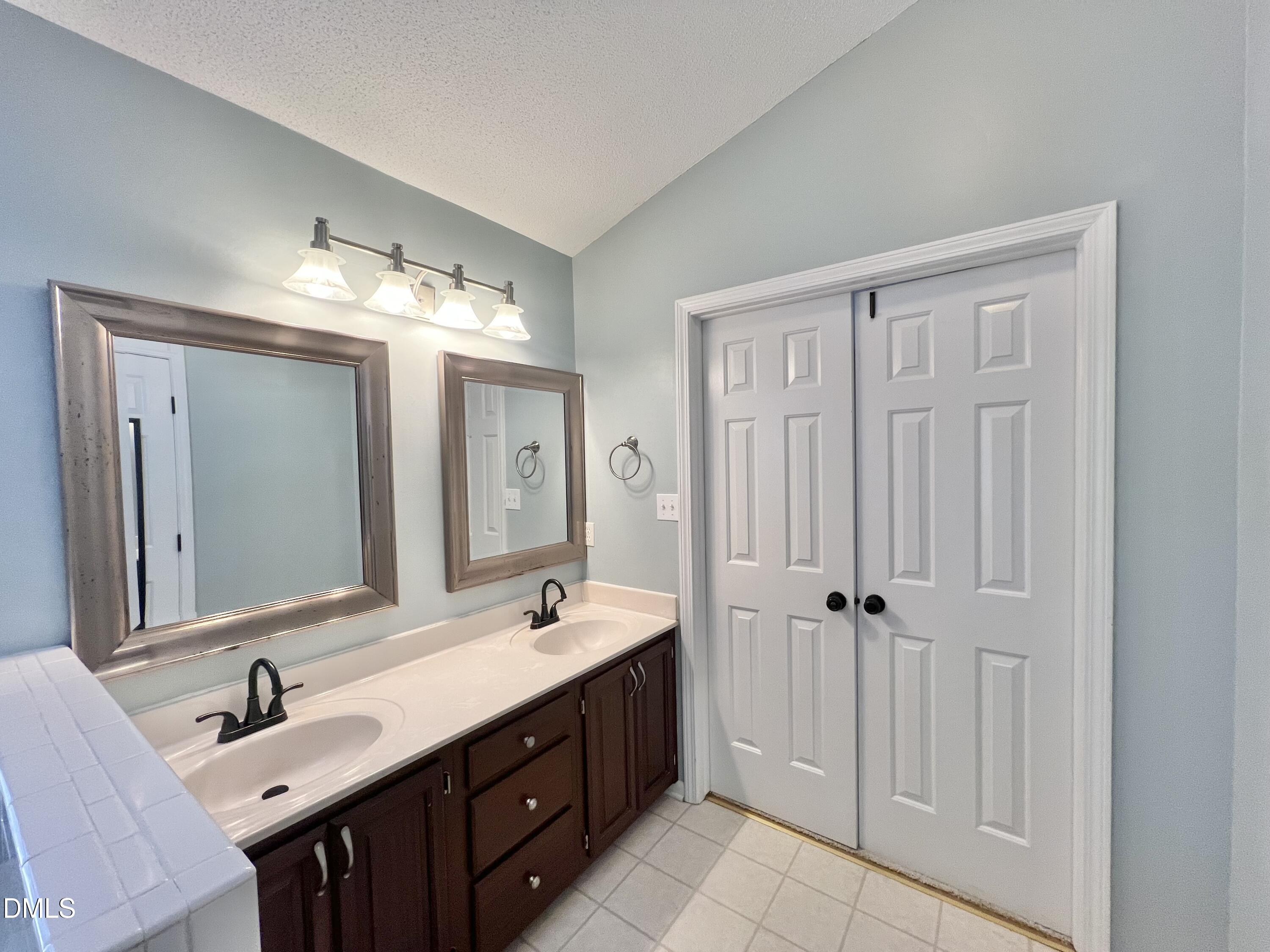 1713 Tealwood Place Raleigh, NC 27615 - Photo 15 of 26 a bathroom with a double vanity sink mirror double and shower
